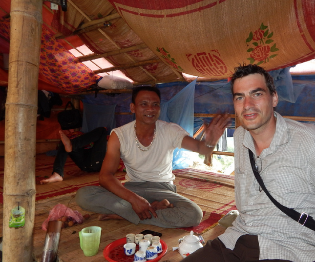 Inside Construction Tent, man invites us for tea and liquor